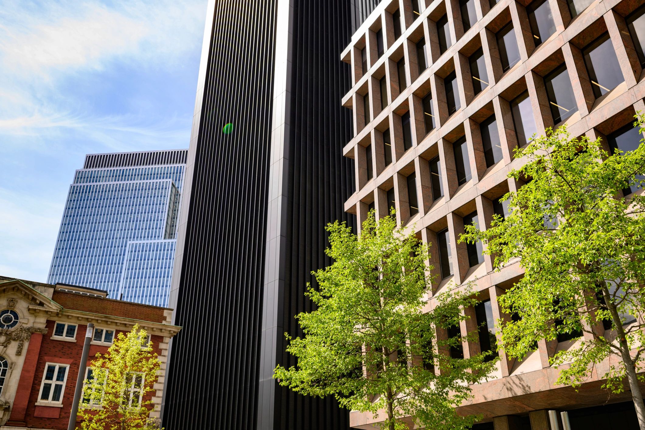 Modern city buildings with glass, steel, and landscaped streetscape